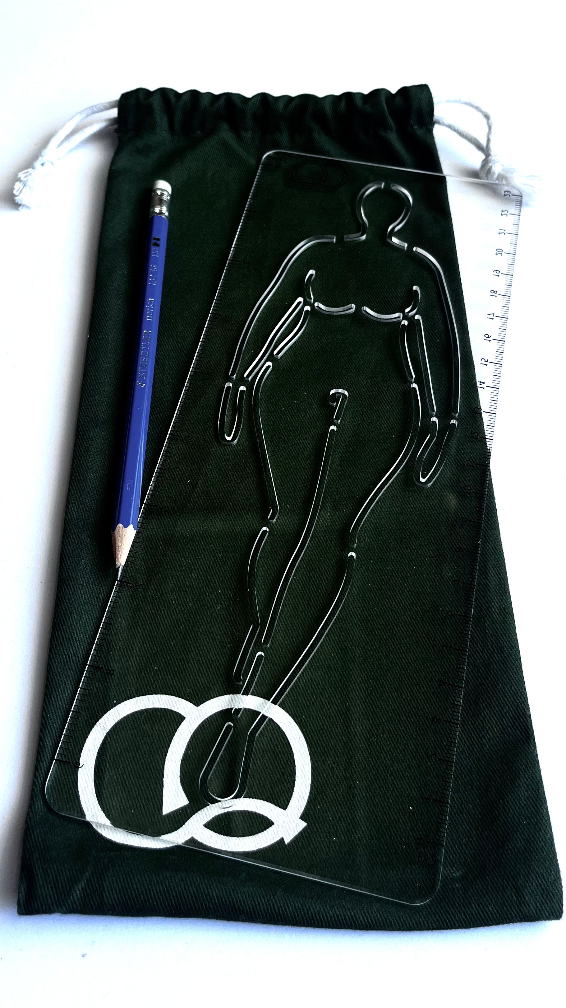 A vibrant green drawstring canvas carry bag featuring a collection of fashion stencils. The bag is made of durable fabric and has a drawstring closure at the top. Viewed from the front, with a stencil and pencil in front of it.